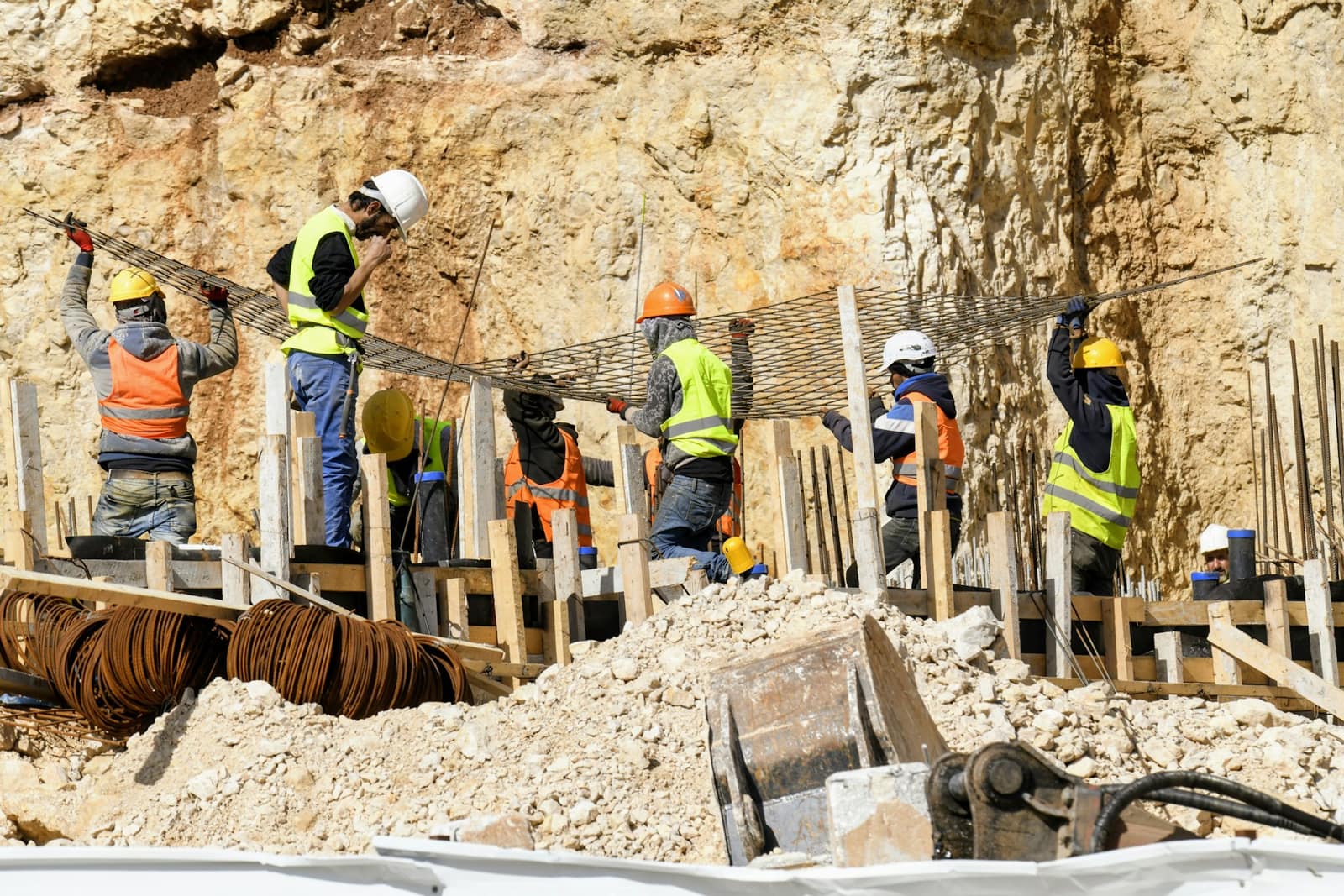 Tikinti meydançasında birgə işləyən fəhlələr qrupunun geniş kadrda görünüşü